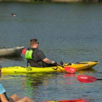 people in single kayaks floating on a river